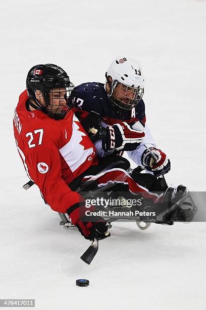 Brad Bowden of Canada competes with Joshua Sweeney of the USA during the Ice Sledge Hockey semifinal match between the USA and Canada at the Shayba...