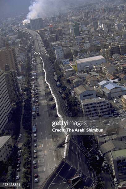 In this aerial image, the Hanshin Expressway elevated highway collapses while smoke begins to rise on Janaury 17, 1995 in Kobe, Hyogo, Japan....