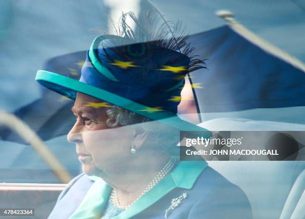 An EU flag is reflected on the window of Britain's Queen Elizabeth II's car as she arrives at the military airport Tegel in Berlin to fly to...