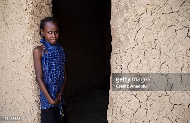 Chadian girl stands next to door of a house at a slumdog of N'djamena, Chad on June 22, 2015. Referred to as the "Dead Heart of Africa", the majority...