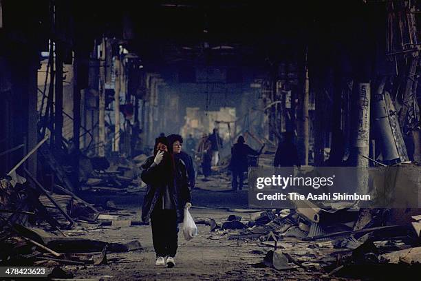 Survivors walk at the burnt shopping street on Janaury 18, 1995 in Kobe, Hyogo, Japan. Magnitude 7.3 strong earthquake jolted in the morning of...