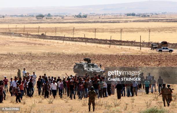 Turkish Kurds gather in Suruc in Sanliurfa province on the Turkish-Syrian border to show support for the people of the Syrian town of Kobane on June...