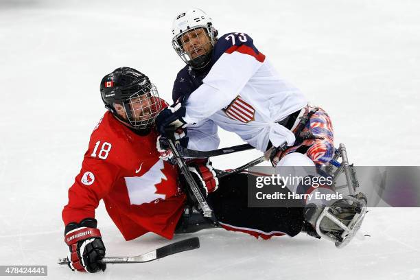 Billy Bridges of Canada collides with Rico Roman of USA during the Ice Sledge Hockey semifinal match between Canada and USA at Shayba Arena during...