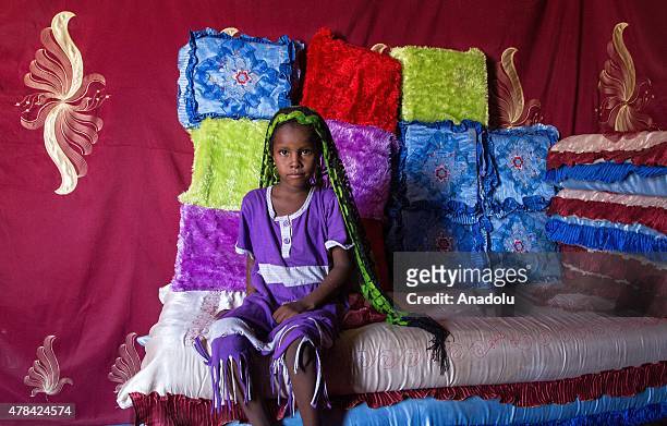 Chadian girl sits on a sofa with colorful pillows at a slumdog of N'djamena, Chad on June 22, 2015. Referred to as the "Dead Heart of Africa", the...