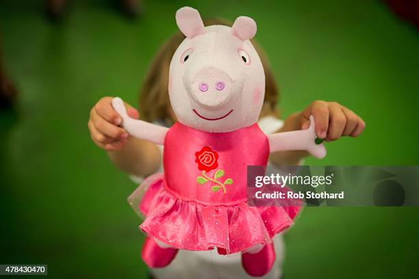 Boy holds a 'One Upon A Time Princess Rose' Peppa Pig toy at Hamleys on June 25, 2015 in London, England. This Peppa Pig, which will sing by having...
