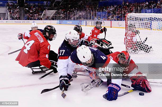 Goalkeeper Corbin Watson of Canada stretches for the puck under the pressure of Joshua Pauls and Brody Roybal of the United States during the Ice...