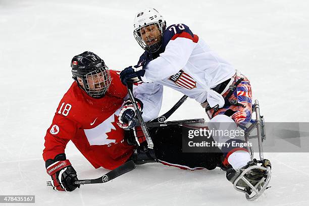 Billy Bridges of Canada collides with Rico Roman of USA during the Ice Sledge Hockey semifinal match between Canada and USA at Shayba Arena during...