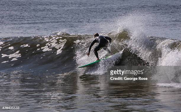 Surfer catches a wave at Will Rogers State Beach on March 3 in Santa Monica Beach, California. Millions of tourists flock to the Los Angeles area to...