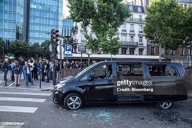 Daimler AG Mercedes-Benz people carrier sits badly damaged after being targeted by taxi drivers during a protest against Uber Technologies Inc.'s car...