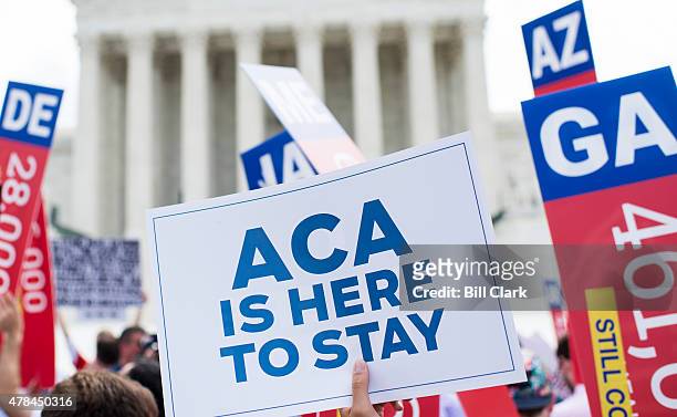 Affordable Care Act supporters wave signs outside the Supreme Court after the court upheld court's Obamacare on Thursday, June 25, 2015.