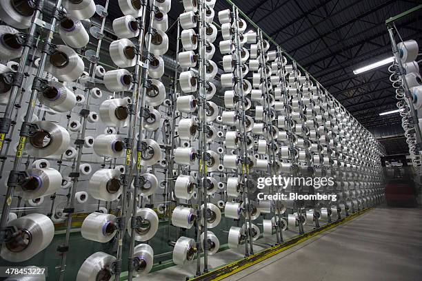 Spools of filament sit on racks that are strung to a machine that makes Velcro material at the Velcro USA Inc. Manufacturing facility in Somersworth,...