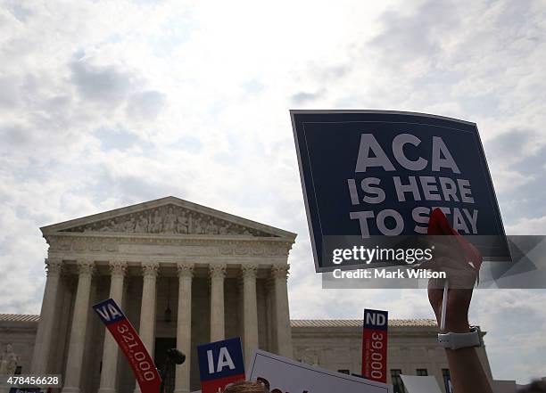 Sign is held up that reads "ACA Is Here To Stay" front of the US Supreme Court after ruling was announced in favor of the Affordable Care Act. June...