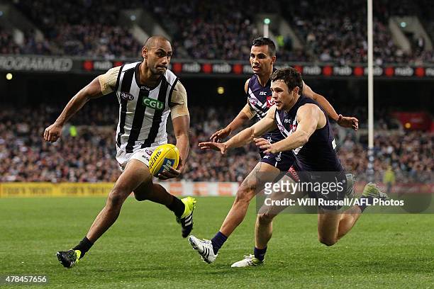 Travis Varcoe of the Magpies looks to pass the ball during the round 13 AFL match between the Fremantle Dockers and the Collingwood Magpies at Domain...