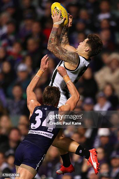 Jamie Elliott of the Magpies marks the ball against Lee Spurr of the Dockers during the round 13 AFL match between the Fremantle Dockers and the...