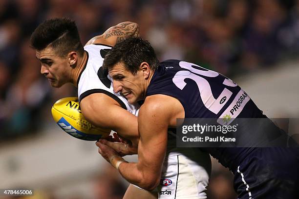 Marley Williams of the Magpies gets tackled by Matthew Pavlich of the Dockers during the round 13 AFL match between the Fremantle Dockers and the...