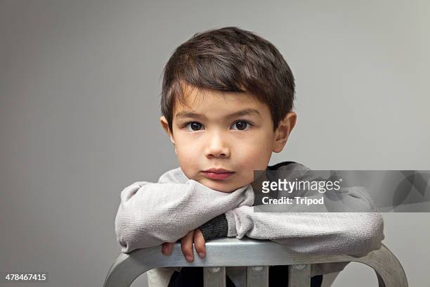 boy (4-6) leaning on chair, portrait - brown hair stock pictures, royalty-free photos & images