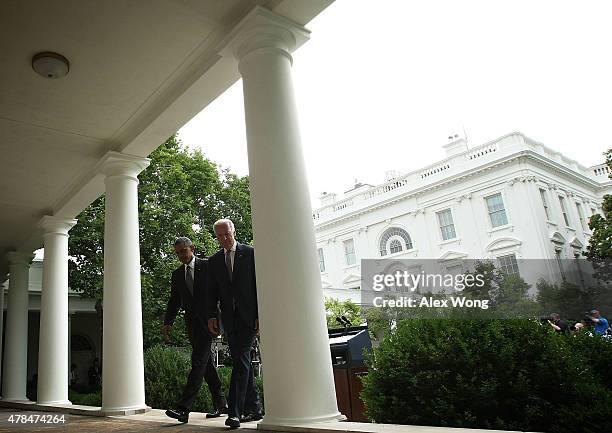 President Barack Obama leaves with Vice President Joe Biden after he gave a statement on the Supreme Court health care decision in the Rose Garden at...