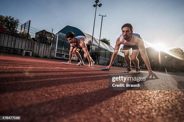 below view of determined athletes ready to start relay race. - relay race start line stock pictures, royalty-free photos & images