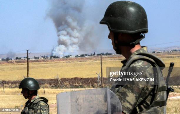 Turkish soldiers stand guard by the border with Syria, on the way to Mursitpinar crossing gate in Suruc, Sanliurfa province, on June 25, 2015. Turkey...