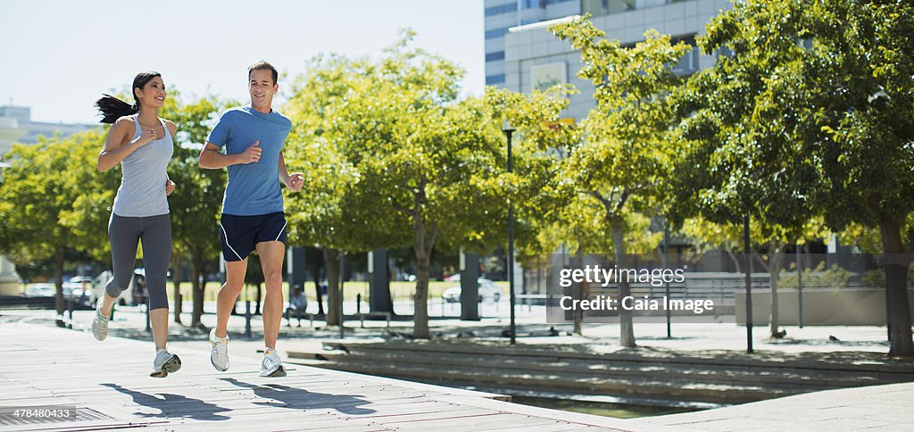 Couple jogging on urban sidewalk