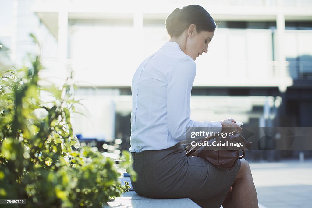 Businesswoman text messaging outdoors