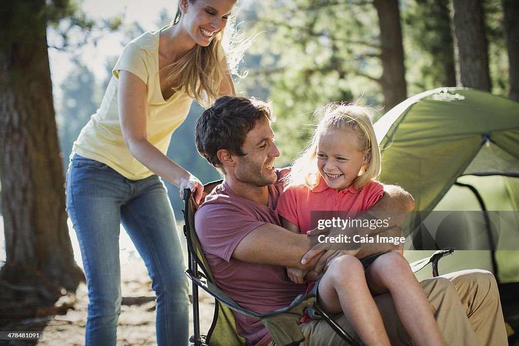 Smiling family at campsite in woods