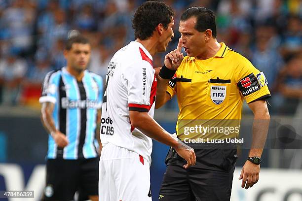 Marcos Caceres of Newell's Old Boys argue with the referee Carlos Amarilla during the Copa Bridgestone Libertadores 2014 match between Gremio v...