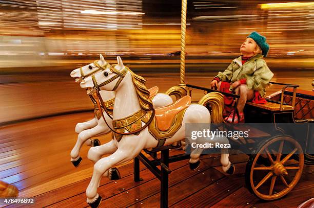 November 25 Fountain Square, Baku, Azerbaijan. A young girl rides on a carrousel in Baku at night.