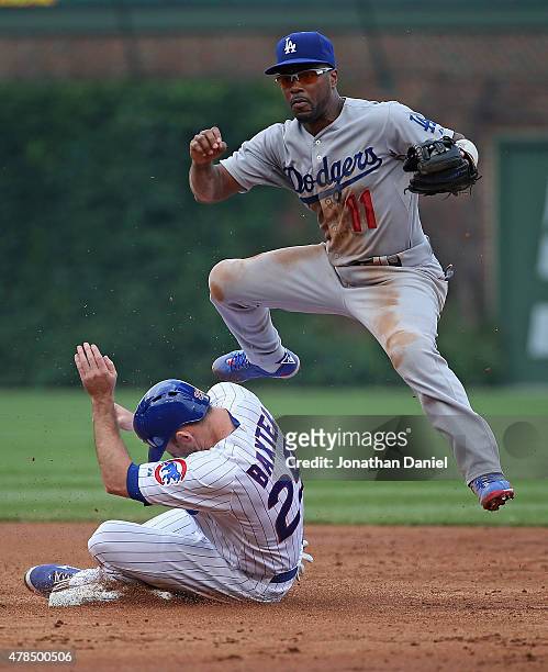 Jimmy Rollins of the Los Angeles Dodgers jumps over Mike Baxter of the Chicago Cubs before turning a double play in the 2nd inning at Wrigley Field...