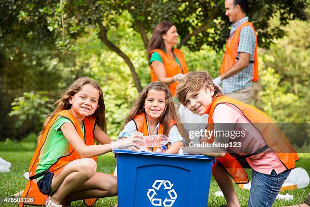 volunteers: family cleans up their community park. recycling bin. - recycling bin stock pictures, royalty-free photos & images