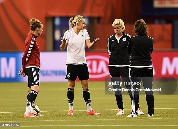 Lena Goessling of Germany exchanges words with head coach Silvia Neid during a training session at Stade Olympique de Montreal on June 25, 2015 in...