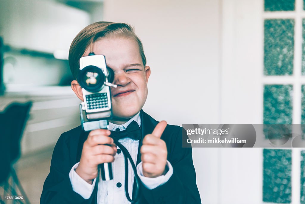Thumbs up from boy shooting video with retro camera