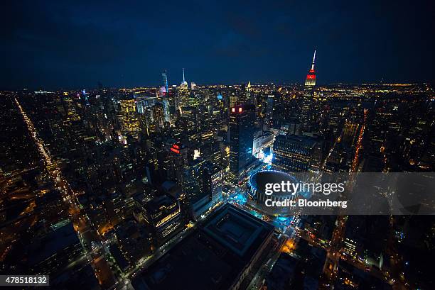 The Empire State Building and Madison Square Garden stand in the Manhattan skyline at dusk in this aerial photograph taken above New York, U.S., on...