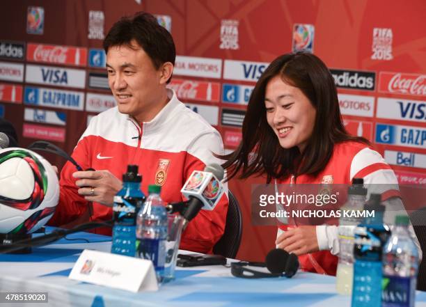 China's national team coach Hoa Wei and defender Wu Haiyan arrive at a press conference at Lansdowne Stadium in Ottawa on June 25, 2015 on the eve of...