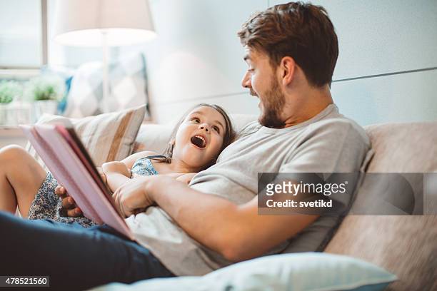 padre e hija disfrutando de su hogar lejos del hogar. - reading fotografías e imágenes de stock