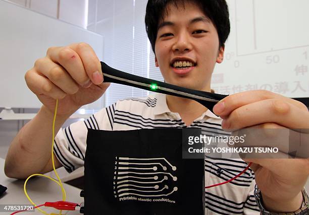 This picture taken on June 24, 2015 shows Naoji Matsuhisa, a doctoral student of Japan's University of Tokyo showing a printed elastic electric...