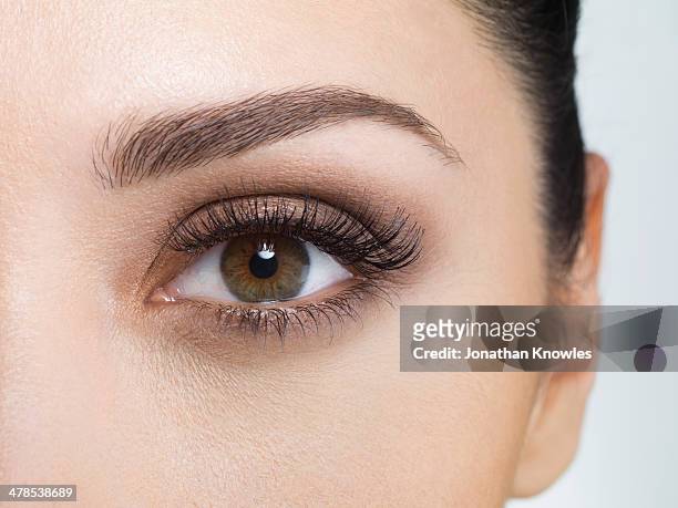 young woman wearing eye make-up, close-up - braune augen stock-fotos und bilder