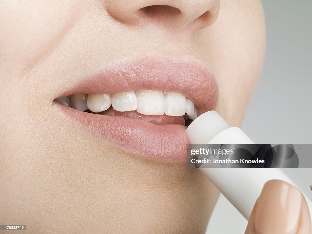 Female applying lip balm, close up