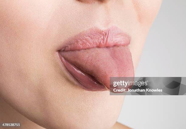 female sticking out tongue, close up - zunge herausstrecken stock-fotos und bilder