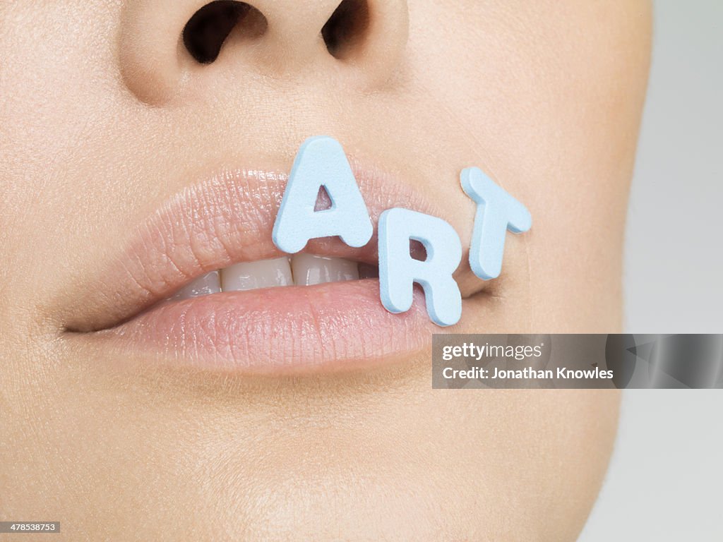 Female with letters forming word ART on lips