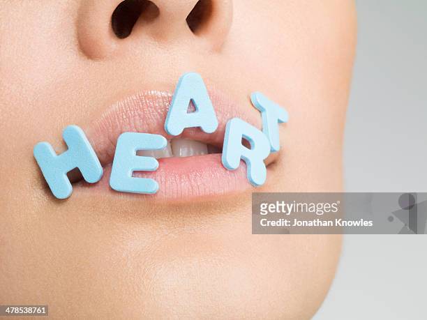 female with letters forming word heart on lips - word of mouth stock pictures, royalty-free photos & images