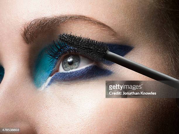 female applying mascara, close up - gray eyes stock-fotos und bilder