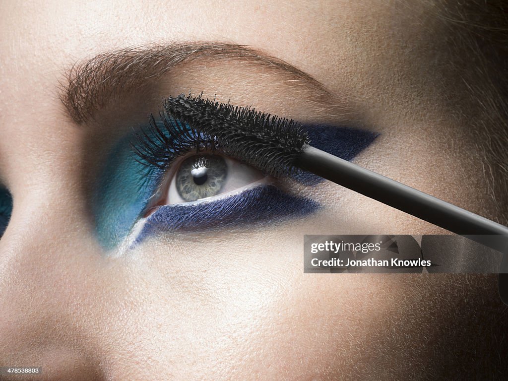 Female applying mascara, close up