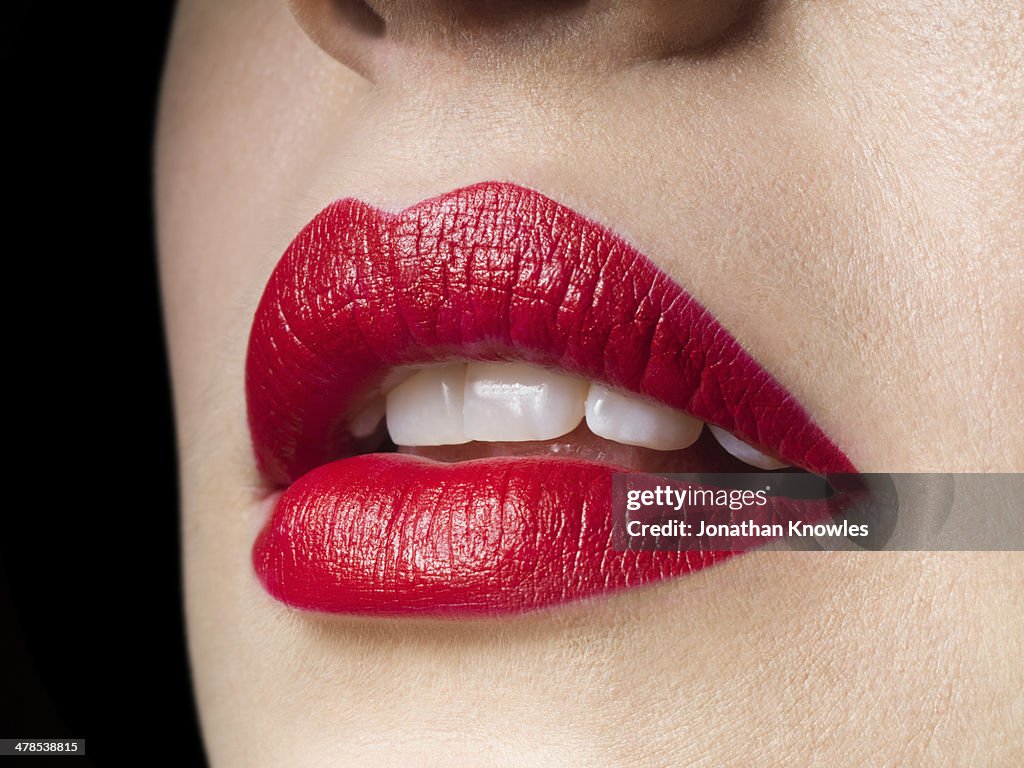 Female lips with red lipstick on, perfect teeth