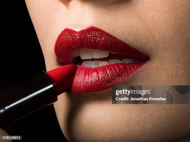 female applying red lipstick, close up - applying lipstick ストックフォトと画像