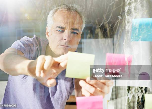 mature man sticking down lost it note - forgot something stockfoto's en -beelden