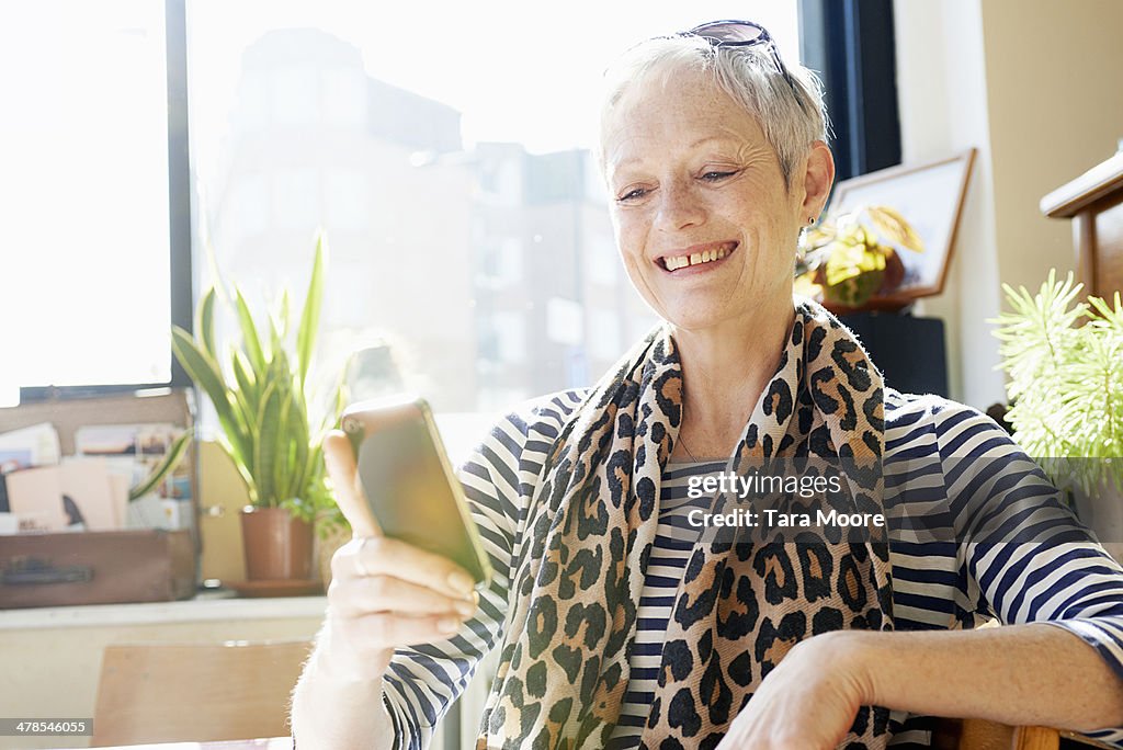 Mature woman smiling with mobile