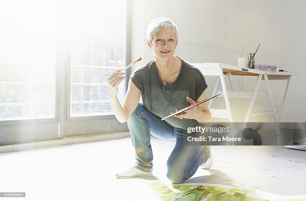 Mature woman painting in studio