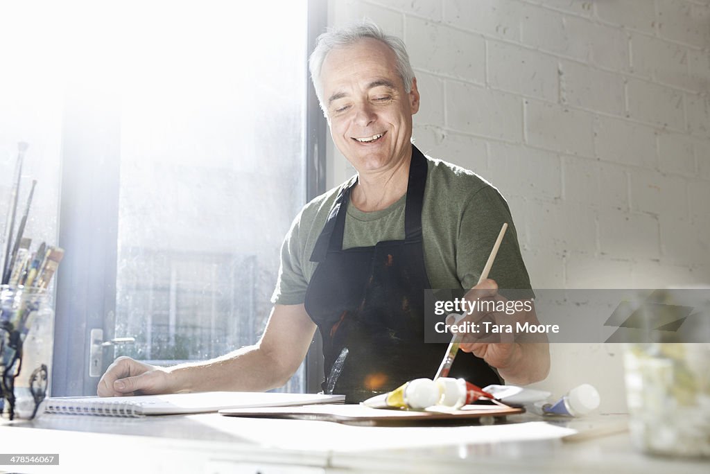 Mature man painting in studio