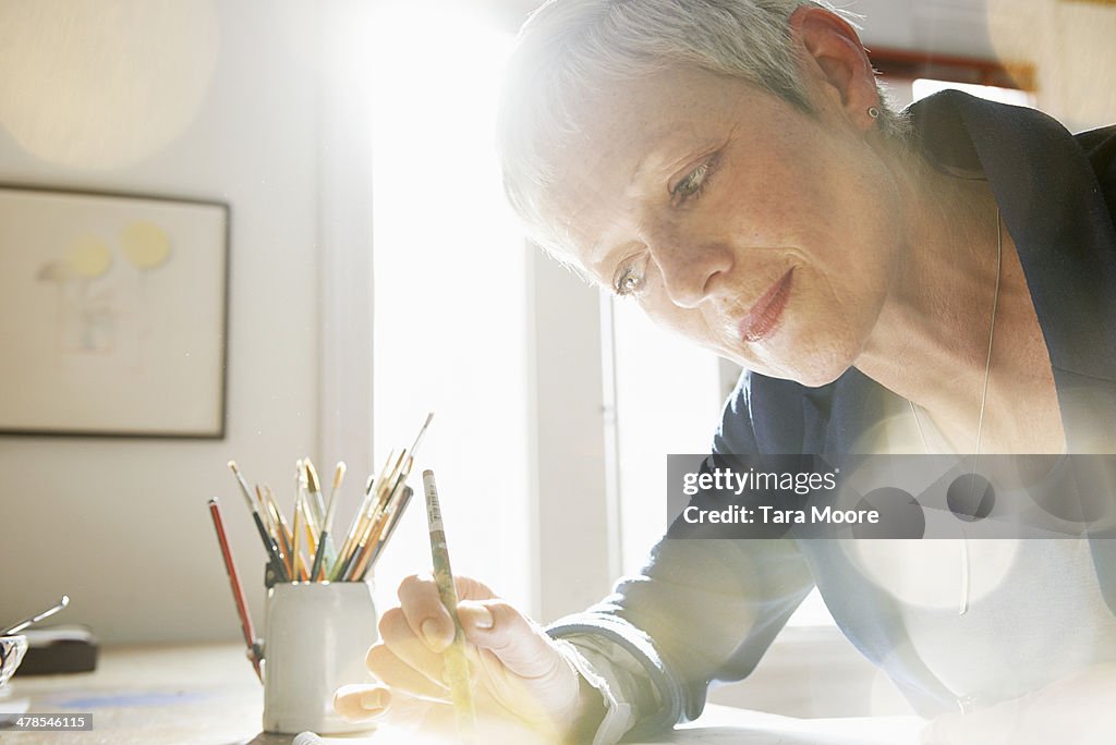 Mature woman painting in studio